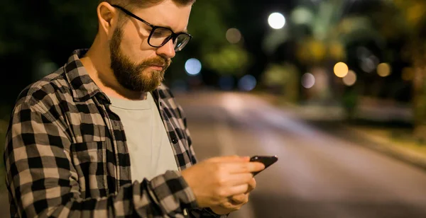 Bearded Man Wearing Eyeglasses Holding Scrolling Texting His Cellphone Night — Zdjęcie stockowe
