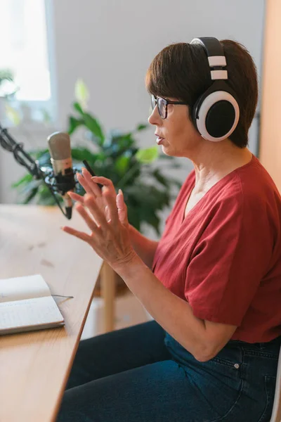 Middle-aged woman radio host making podcast recording for online show - broadcast and dj