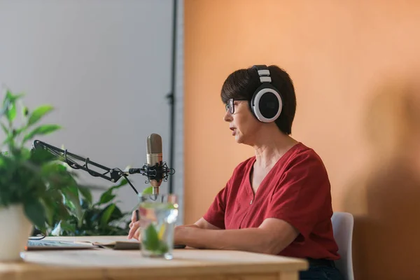 Portrait Mature Woman Wearing Headphones Talking Online Radio Station Podcast — Foto de Stock