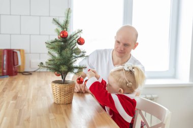 Father with toddler daughter with cochlear implants having fun in living room health care and innovating treatment for deafness with cochlear implant surgery