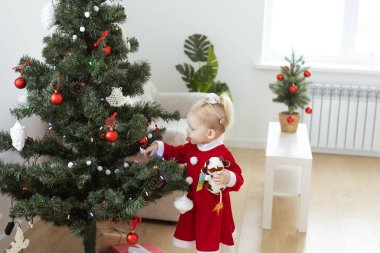 Toddler child with cochlear implant decorating christmas tree deafness and innovating medical technologies for hearing aid