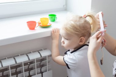 Anne kızının koklear implant işitme cihazını tamir ediyor. Sağırlık ve çeşitlilik kavramı. Tedavi sağırlığında yenilikçi teknolojiler