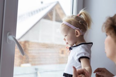 Baby with cochlear implant hearing aid having fun with her mother - deafness and diversity concept. Copy space place for advertising