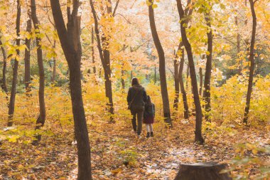 Anne ve küçük kızı sonbahar parkında sonbahar mevsiminde