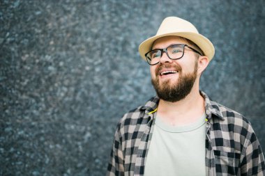 guy tourist looking happy wearing straw hat for travelling, standing against concrete wall background with copy space