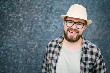 guy tourist looking happy wearing straw hat for travelling, standing against concrete wall background with copy space