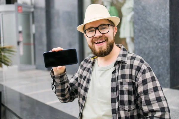 Happy Bearded Man Showing Blank Smartphone Screen Green Leaves Background — Foto de Stock