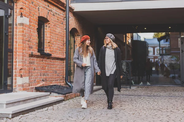 Две Девушки Идут Вместе Улице Держатся Руки Весенняя Осенняя Одежда — стоковое фото