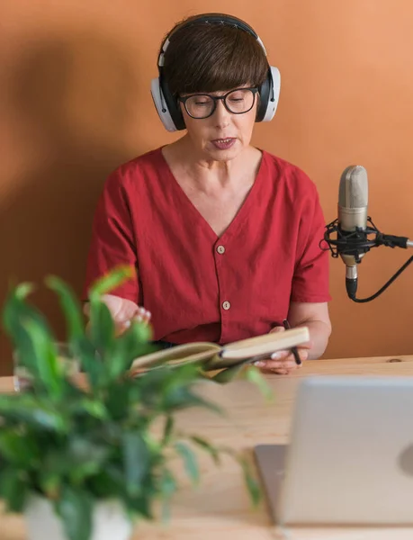 Middle-aged woman radio host making podcast recording for online show - broadcast and dj