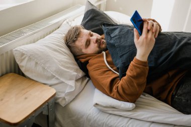 Cep telefonu kullanan serbest çalışan, sosyal medya ağını kontrol eden ya da evdeki yatakta oturup mesajlaşan biri. Sıkı çalışma gününden sonra çevrimiçi dijital iletişim dinlenme