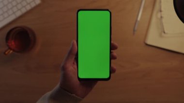 Erkek elinde krom anahtar ekranlı cep telefonunun üst görünümü