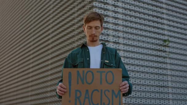 Rotschopf posiert draußen mit Nein zu Rassismus-Banner — Stockvideo