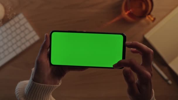Женские руки прокручивают и постукивают по мобильному зеленому экрану — стоковое видео