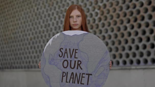 Молодая женщина держит картон с спасением нашей планеты фраза — стоковое видео