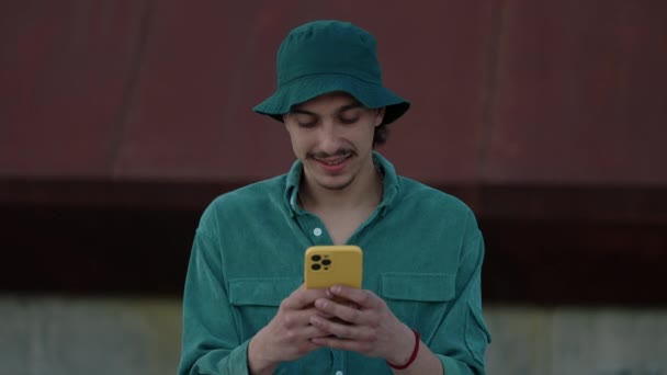 在城市街道上用手机微笑的年轻人 — 图库视频影像