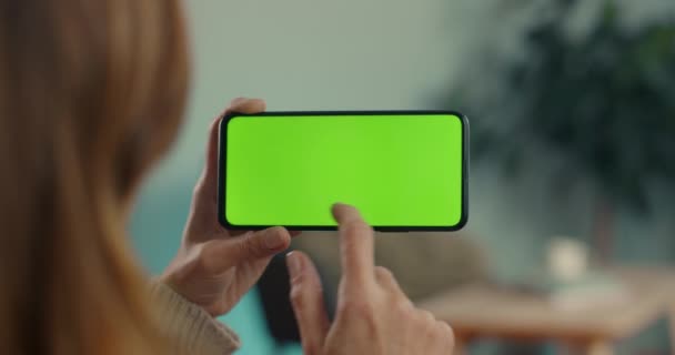 Mujer caucásica deslizándose en la pantalla verde del teléfono inteligente — Vídeos de Stock