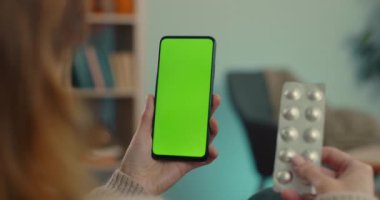 Yeşil ekran telefonunda doktorla görüntülü konuşma yapan kadın.