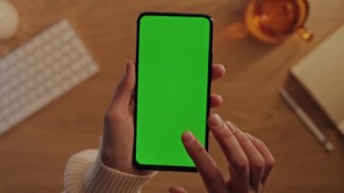 Yeşil ekranlı akıllı telefon kullanan kadının üst görünümü