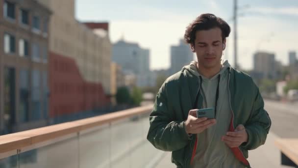 Hombre usando auriculares y móviles para escuchar música al aire libre — Vídeos de Stock