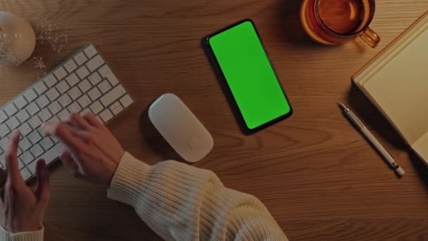 Kobieta wpisując na klawiaturze i za pomocą telefonu komórkowego zielony ekran — Wideo stockowe