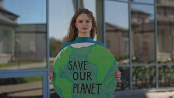 Кавказская женщина держит знамя с фразой спасти нашу планету — стоковое видео
