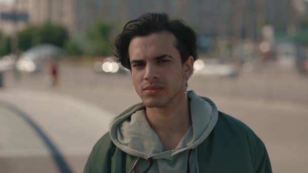 Retrato de un joven con la cara tranquila posando en la calle de la ciudad — Vídeos de Stock