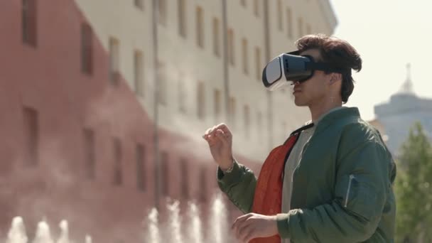 Homem em fone de ouvido com experiência de realidade virtual na rua — Vídeo de Stock