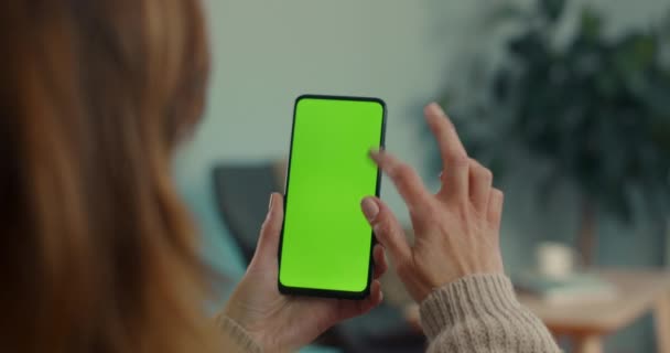 Mujer desplazándose con el dedo en la pantalla verde del móvil — Vídeos de Stock