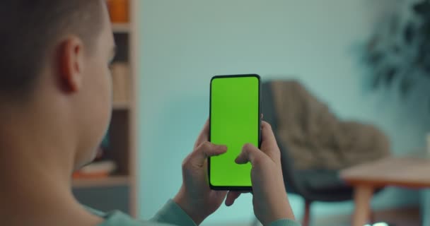 Man typen van berichten op mobiel met groene mock up scherm — Stockvideo