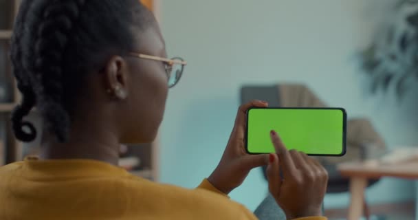 Afrikaans amerikaanse vrouw scrollen en tikken op groen scherm van mobiel — Stockvideo