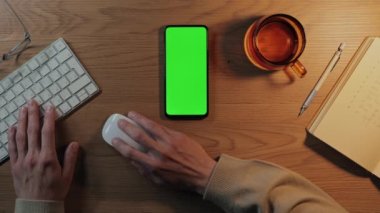 Yeşil ekran ve klavyeli mobil üzerinde çalışan adam
