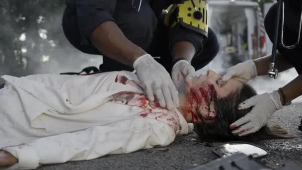 Ratownicy medyczni pomagają rannej kobiecie po wypadku samochodowym — Wideo stockowe
