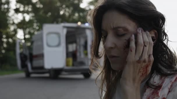 負傷した白人女性は道路上で救急車を待っています — ストック動画