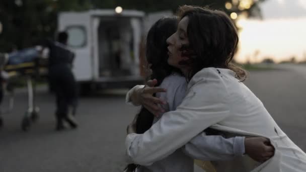 Madre abrazando a la hija mientras los médicos ayudan a padre — Vídeos de Stock