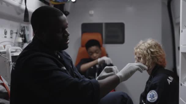 Afrikansk amerikansk sjukvårdare korsar sig själv när han åker i ambulans — Stockvideo