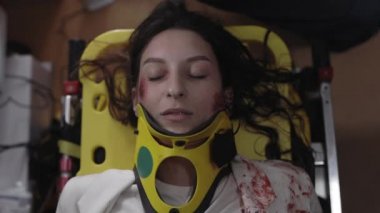 Sağlık görevlileri ambulanstaki kadın hasta için oksijen maskesi kullanıyor.