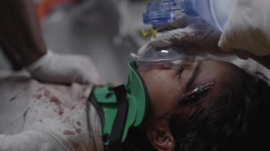 Sağlık görevlileri ambulanstaki çocuğa kalp masajı yapıyor.