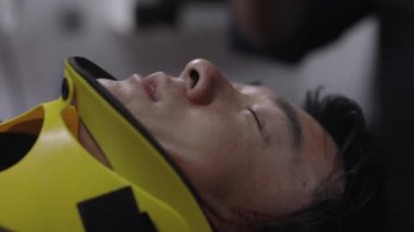 Ambulanstaki yaralı adam için oksijen maskesi kullanılıyor.