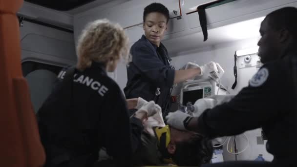 Squadra di paramedici che soccorre il paziente con defibrillatore — Video Stock