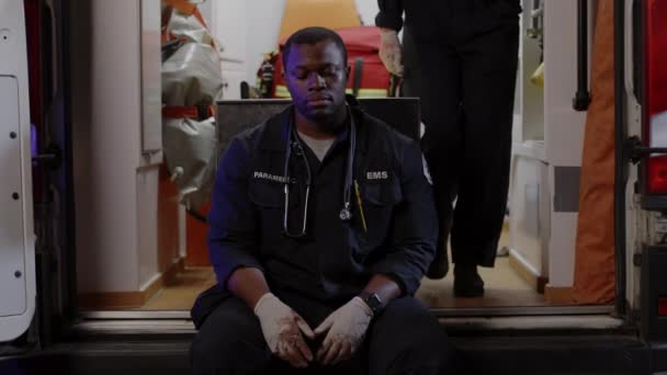 African american paramedic feeling down while sitting in ambulance — Stock Video