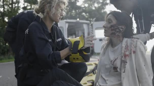 Team av paramedics som ger första hjälpen för kvinna på vägen — Stockvideo