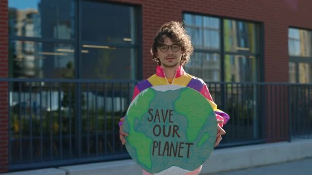 Портрет молодого парня, держащего знамя со спасением нашей планеты — стоковое видео
