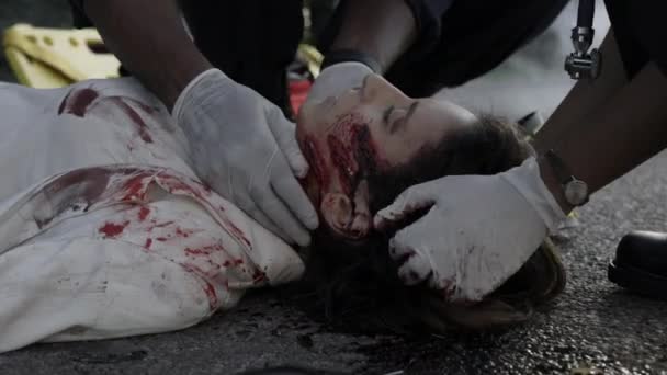 Sjukvårdare räddar livet på sårad kvinna på vägen — Stockvideo