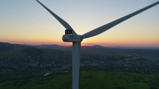 Widok z drona turbiny wiatrowej stale pracuje na polu. Piękny letni zachód słońca na tle. Farma wiatrowa do produkcji zielonej energii. — Wideo stockowe