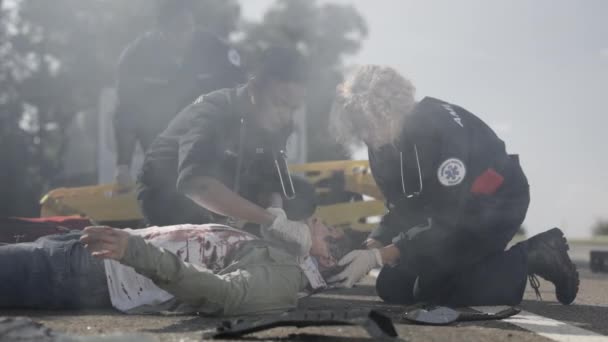 Équipe de paramédics secourant blessé asiatique homme — Video