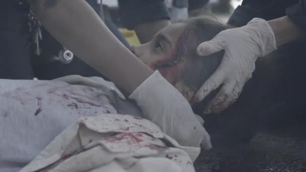 Indian child getting emergency care from paramedics on road — Stock Video