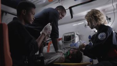 Sağlık görevlileri ambulansta kurban için ilk yardım sağlıyor.