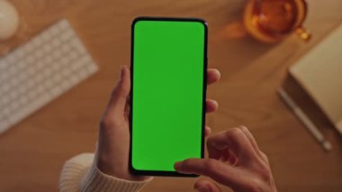 Kadın elleri yeşil ekranlı cep telefonunda kayıyor