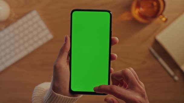 Женские руки прокручивают на мобильном телефоне зеленый мак-экран — стоковое видео