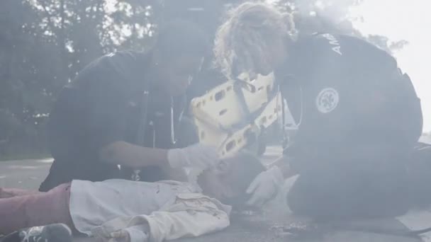 Team av multiracial paramedics hjälpa små skadade flicka — Stockvideo